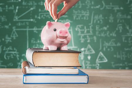 Frau steckt Geld in ein Sparschwein