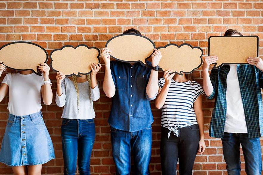 Young adults holding up copy-space placard thought bubbles